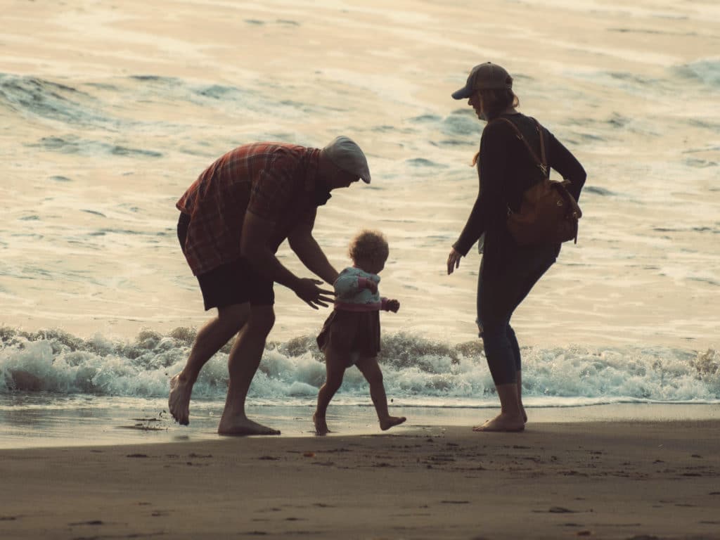 Photo de parents et de leur enfants qui s'amusent sur la plage