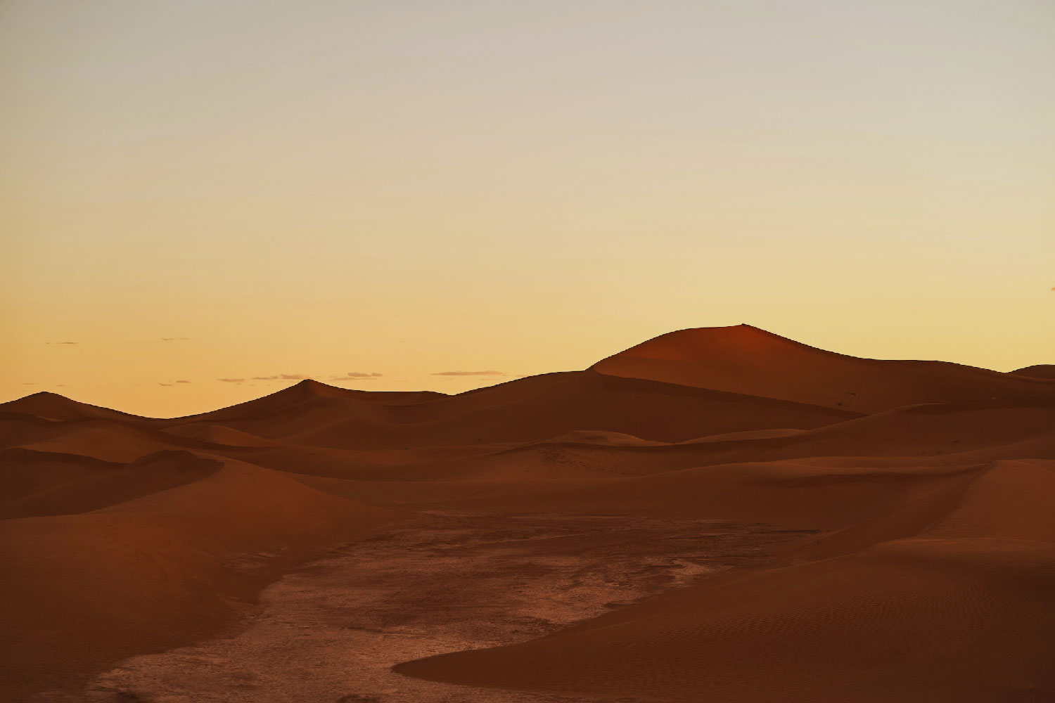 Photo de dunes dans le désert au couché du soleil